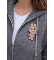 Pembe Sevimli Figürlü Metal Rozet – Çiçek Detaylı Karakter Çanta Aksesuarı Pin