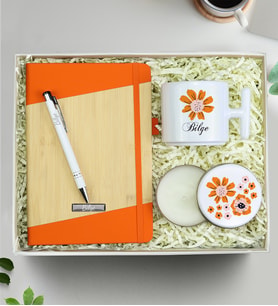 Kişiye Özel Turuncu Defter & T Kupa & Gümüş Renk Detaylı Beyaz Tükenmez Kalem & Çiçekli Beyaz Metal Kutulu Mum Hediye Seti