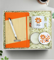 Kişiye Özel Turuncu Defter & T Kupa & Gümüş Renk Detaylı Beyaz Tükenmez Kalem & Çiçekli Beyaz Metal Kutulu Mum Hediye Seti