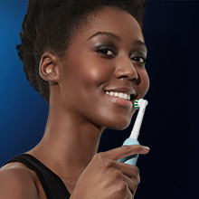 Diş eti basınç sensörü Diş eti basınç sensörüyle donatılan Oral-B Pro Series 1 diş fırçasıyla dişlerini fırçalayan kadın.