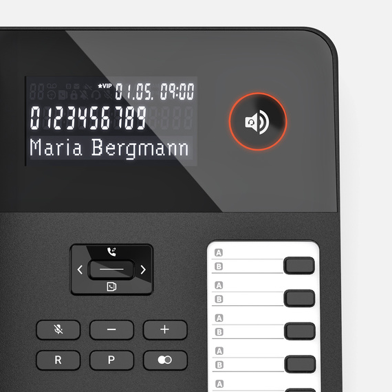 Close-up of a desk phone with a display and function keys, the name ‘Maria Bergmann’ is displayed.