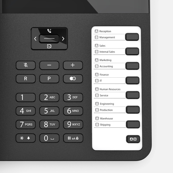 Close-up of a desk phone with function keys and a paper insert for direct dialling numbers.